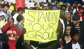 Marchers hold up their signs as they walk to the Florida Capitol Monday, March 10, 2014, for a rally in Tallahassee, Fla. Participants were rallying against the state&#39;s &amp;quot;Stand Your Ground&amp;quot; laws. (AP Photo/Phil Sears)