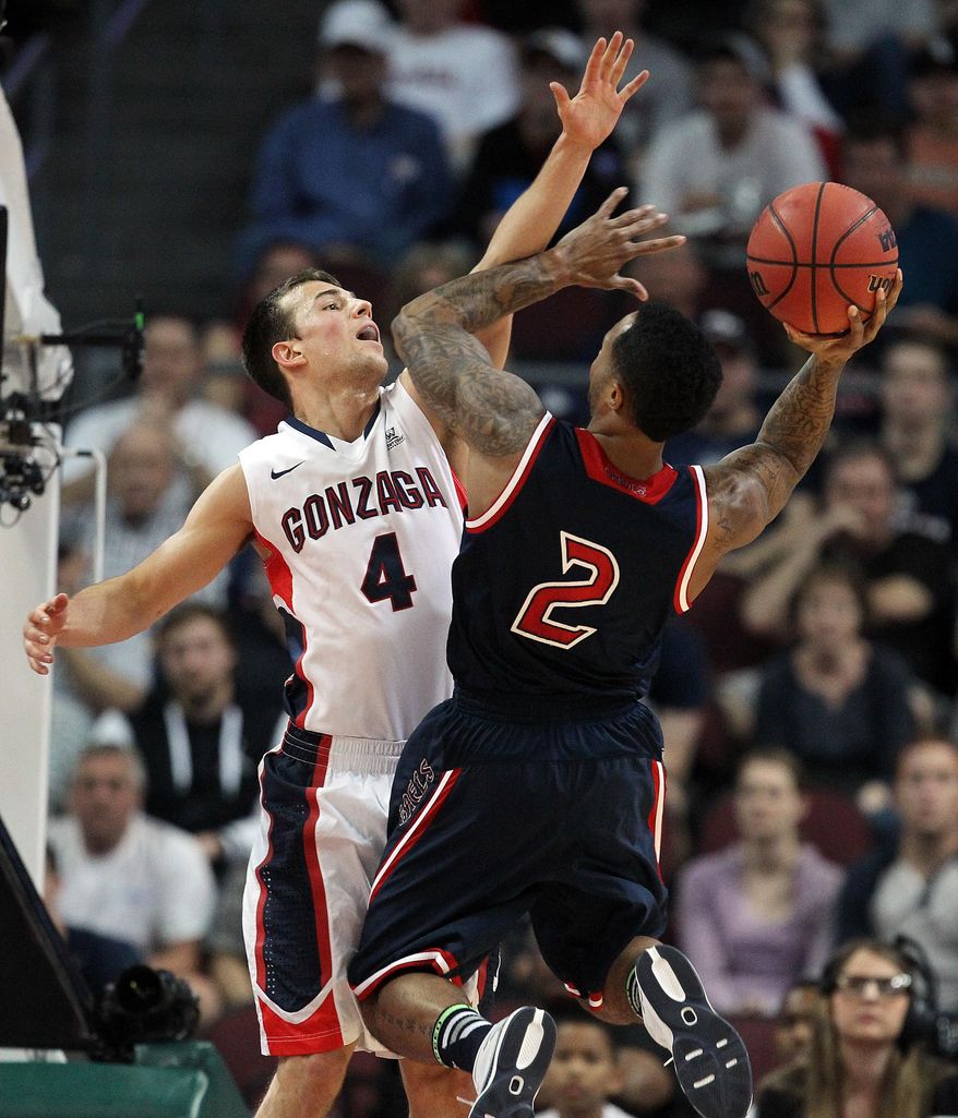 Gonzaga's Kevin Pangos covers a shot from Saint Mary's Paul McCoy during the first half of a West Coast Conference tournament NCAA college basketball game, Monday, March 10, 2014, in Las Vegas. (AP Photo/Isaac Brekken)