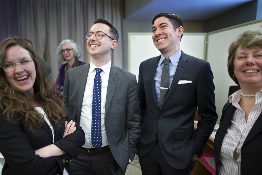 Thomas Rimbey Ogletree, center left, and Nicholas Haddad, center right, smile following a news conference announcing that a case against Ogletree's father, Rev. Thomas Ogletree, for breaking church law by officiating their same-sex marriage had been dropped, Monday, March 10, 2014, in White Plains, N.Y. Bishop Martin McLee, who announced the decision, called on church officials to stop prosecuting other pastors for marrying same-sex couples. McLee, who leads the church's New York district said he would cease church trials over the issue in his district and would organize a broad discussion about the church's internal divisions over gay relationships. (AP Photo/John Minchillo)