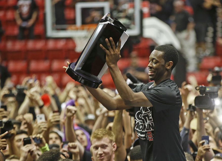 San Diego State 's Xavier Thames holds the conference trophy after State's 51-48 victory over New Mexico that captured the Mountain West Conference regular season championship in a NCAA college basketball game Saturday, March 8, 2014, in San Diego. (AP Photo/Lenny Ignelzi)