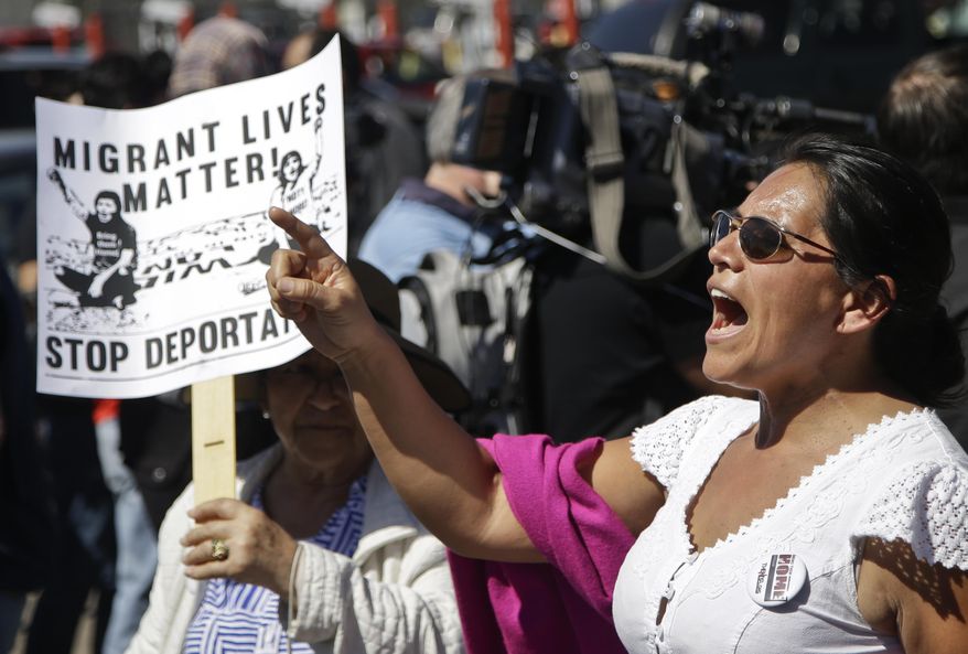Estella Jimenez, of the group Border Angels, leads a chant for members of the group Border Dreamers and other supporters of an open border policy just outside the port of entry into United States Monday, March 10, 2014, in Tijuana, Mexico. (AP Photo/Lenny Ignelzi)