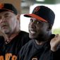 San Francisco Giants manager Bruce Bochy, left, listens as former player Barry Bonds speaks at a news conference before a spring training baseball game in Scottsdale, Ariz., Monday, March 10, 2014. Bonds starts a seven day coaching stint today. (AP Photo/Chris Carlson)