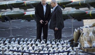 Israel&#39;s Prime Minister Benjamin Netanyahu, right, and Israel&#39;s Defense Minister Moshe Yaalon, left, examine dozens of mortar shells and rockets on display after being seized from the Panama-flagged KLOS C civilian cargo ship that Israel intercepted last Wednesday off the coast of Sudan, at a military port in the Red Sea city of Eilat, southern Israel, Monday, March 10, 2014. Israel has alleged the shipment was orchestrated by Iran and was intended for Islamic militants in Gaza, a claim denied by Iran and the rockets&#39; purported recipients. Questions remain, including how the rockets would have been smuggled into Gaza, largely cut off from the world by a border blockade enforced by Israel and Egypt. (AP Photo/Ariel Schalit)