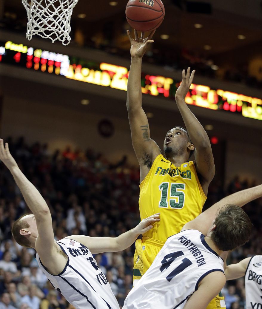 San Francisco's Kruize Pinkins shoots over BYU's defense during the first half of a West Coast Conference tournament NCAA college basketball game Monday, March 10, 2014, in Las Vegas. (AP Photo/Isaac Brekken)