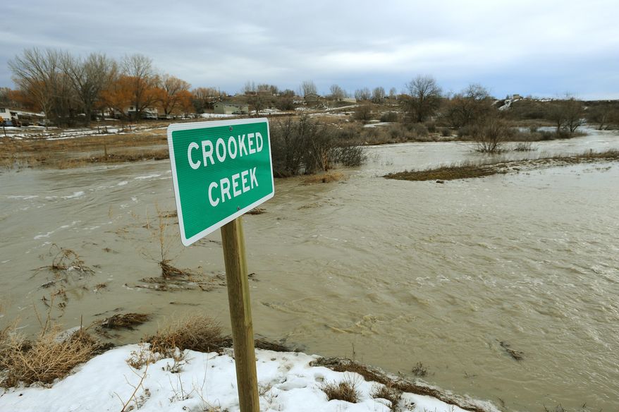 In this photo taken on Sunday, March 9, 2014, Crooked Creek floods near Shepherd, Mont. A new storm Monday night and Tuesday brought more snow to areas of Montana where hundreds of people have been left cut off by swollen rivers and impassable waterlogged roads. Authorities warned that the new precipitation could make the flooding worse. (AP Photo/Billings Gazette, Larry Mayer)