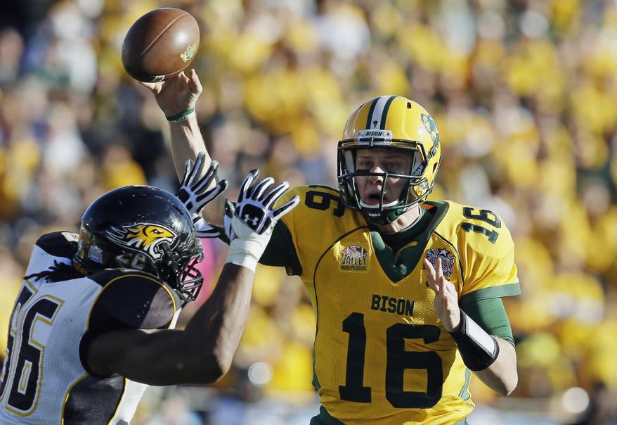 FILE - IN this Jan. 4, 2014 file photo, North Dakota State quarterback Brock Jensen gets a pass off under pressure from Towson defensive end Ryan Delaire during the FCS championship NCAA college football game in Frisco, Texas. NDSU won 35-7. Jensen, who is the winningest quarterback in NCAA Football Championship Subdivision history, is gearing up for his pro day in Fargo on Wednesday, March 12, 2014, after being overlooked for the NFL combine. (AP Photo/Tony Gutierrez, File)
