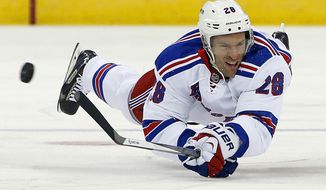 New York Rangers&#x27; Dominic Moore dives for the puck during the first period of an NHL hockey game against the Carolina Hurricanes in Raleigh, N.C., Tuesday, March 11, 2014. (AP Photo/Karl B DeBlaker)