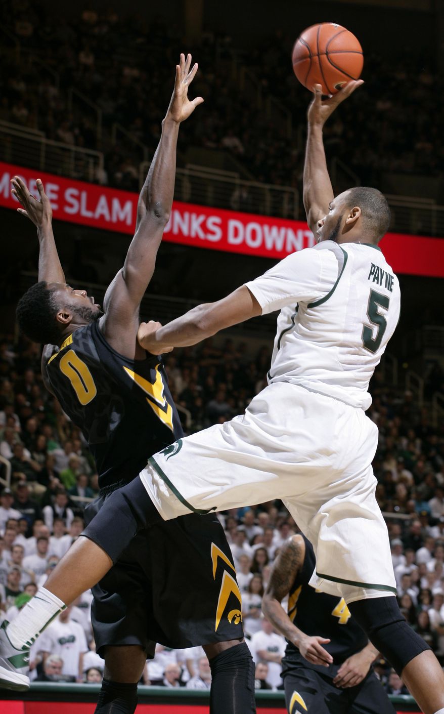 Michigan State's Adreian Payne (5) shoots against Iowa's Gabriel Olaseni (0) during the second half of an NCAA college basketball game, Thursday, March 6, 2014, in East Lansing, Mich. Michigan State won 86-76. (AP Photo/Al Goldis)