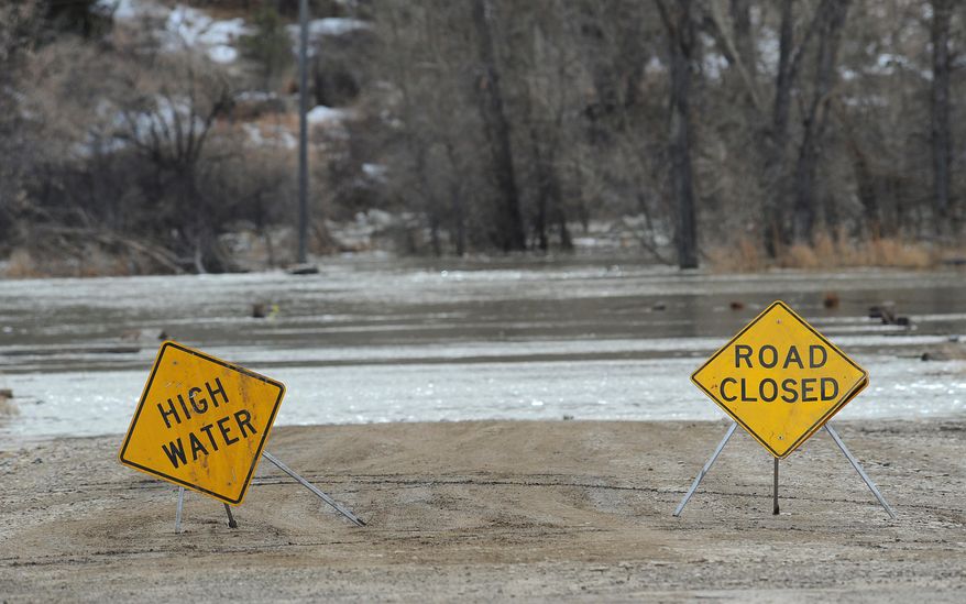 In this photo taken on Sunday, March 9, 2014, the road to the Musselshell County Fairgrounds in Roundup, Mont. was closed due to floodwater. A new storm Monday night and Tuesday brought more snow to areas of Montana where hundreds of people have been left cut off by swollen rivers and impassable waterlogged roads. Authorities warned that the new precipitation could make the flooding worse. (AP Photo/Billings Gazette, Larry Mayer)