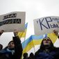 People hold banners that read: &quot;Crimea — Ukraine&quot; during a rally against the breakup of the country in Simferopol, Crimea, Ukraine, Tuesday, March 11, 2014. The Crimean parliament voted Tuesday that the Black Sea peninsula will declare itself an independent state if its residents agree to split off from Ukraine and join Russia in a referendum. (AP Photo/Darko Vojinovic)