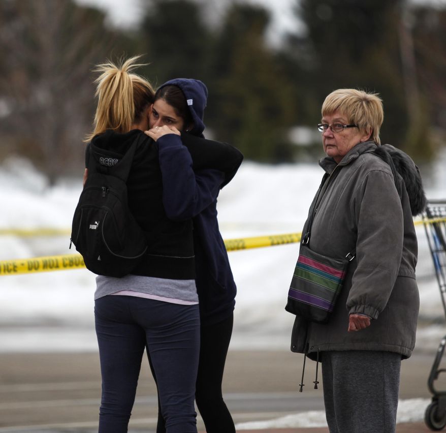Skye Cieszlak, girlfriend of missing Saginaw Spirit hockey player Terry Trafford, is comforted in the parking lot of the Saginaw Township Wal-Mart, Tuesday, March 11, 2014. Police found a 1995 GMC Sierra that matches the description of Terry Trafford's vehicle. Police found a body in the truck but have not yet identified the person. (AP Photo/The Saginaw News, Neil Barris)