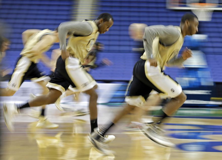 Wake Forest's Travis McKie, left, and Coron Williams, right, run with the team during an NCAA college basketball practice for the Atlantic Coast Conference tournament in Greensboro, N.C., Tuesday, March 11, 2014. Wake Forest plays Notre Dame in a first round game on Wednesday. (AP Photo/Chuck Burton)