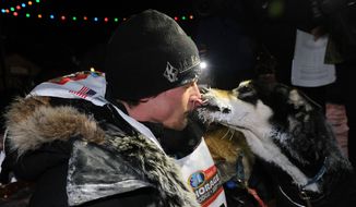 Dallas Seavey gets a kiss from one of his dogs after winning the 2014 Iditarod Trail Sled Dog Race in Nome, Alaska, Tuesday, March 11, 2014. (AP Photo/The Anchorage Daily News, Bob Hallinen)