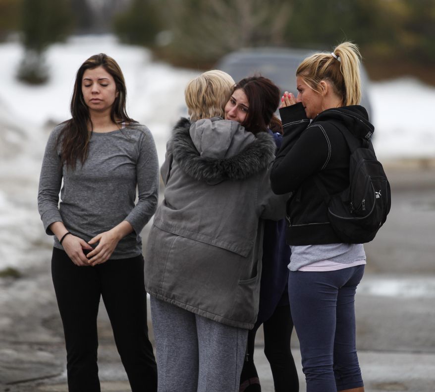 Skye Cieszlak, girlfriend of missing Saginaw Spirit hockey player Terry Trafford, is comforted in the parking lot of the Saginaw Township Wal-Mart, Tuesday, March 11, 2014. Police found a 1995 GMC Sierra that matches the description of Terry Trafford's vehicle. Police found a body in the truck but have not yet identified the person. (AP Photo/The Saginaw News, Neil Barris)