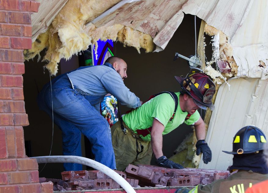 Fire fighters climb out of huge hole caused by flat bed tractor and trailer that crashed into he side of the First Baptist Church in Center Star, Alabama, Monday March 10, 2014, pinning the driver inside.(AP Photo/Times Daily, Matt McKean)