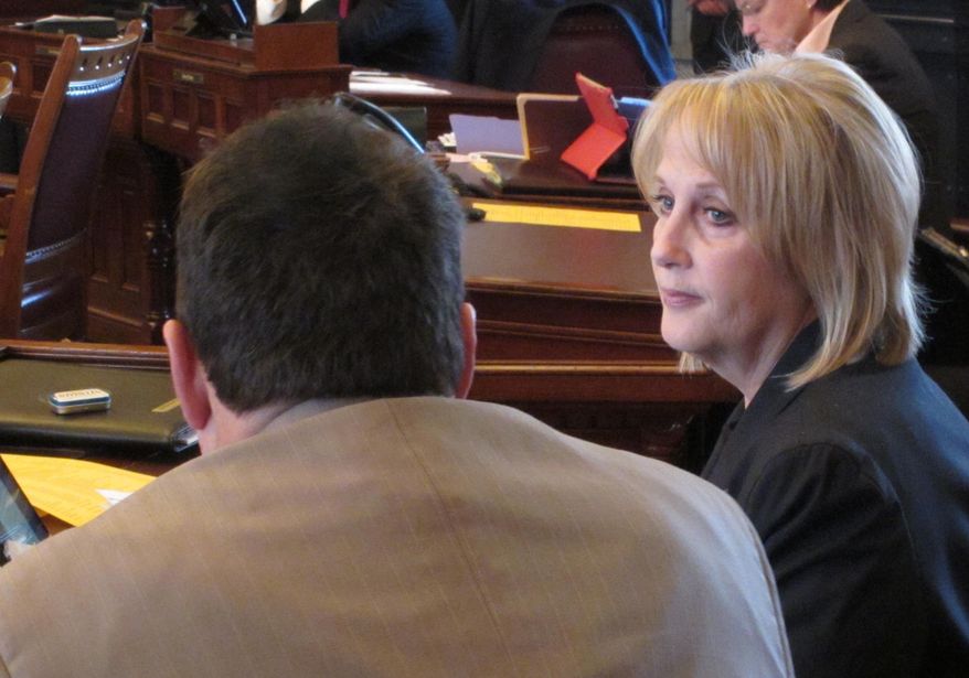 Kansas state Sens. Rob Olson, left, of Olathe, and Mary Pilcher-Cook, right, of Shawnee, both Republicans, confer before the start of a Senate debate on a bill regulating online health insurance marketplace "navigators" for consumers, Tuesday, March 11, 2014, at the Statehouse in Topeka, Kan. Pilcher-Cook is chairwoman of the Senate Public Health and Welfare Committee, which is sponsoring the measure. (AP Photo/John Hanna)