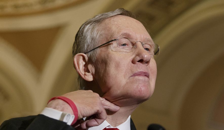 Senate Majority Leader Harry Reid of Nev. makes a cutting gesture across his neck, referencing House Oversight Committee Chairman Rep. Darrell Issa, R-Calif., who caused an uproar last week when he made the same gesture to order microphones cut as the top Democrat on his panel was trying to speak about the Internal Revenue Service scandal over targeting of conservative political groups,  Tuesday, March 11, 2014, during a news conference on Capitol Hill in Washington, Tuesday, March 11, 2014. Reid said that he thought the accusations of IRS misdeeds deserved answers. (AP Photo/J. Scott Applewhite)