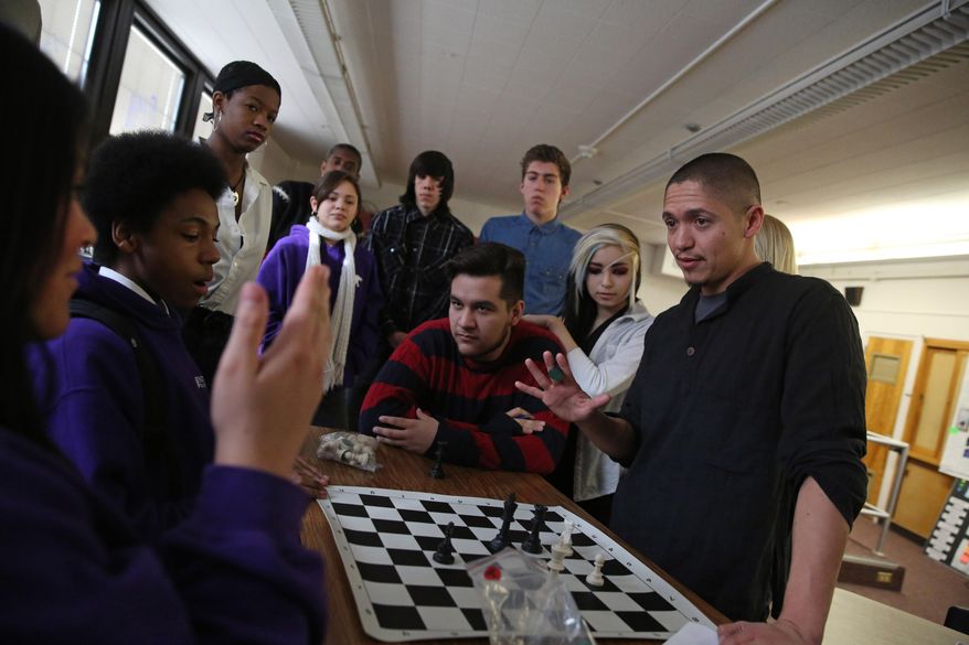 In this Feb. 10, 2014 photo, music emcee and Youth on Record teacher Adrian Molina gestures while using a chess board as a teaching tool during a music composition class at Venture Prep, a charter school that’s part of Denver Public Schools, in Denver. Founded by hip hop group the Flobots, Youth on Record recruits artists, trains them to teach, and puts instruments and professional recording equipment in the hands of young people. It reaches 700 students a year, and currently is working in four Denver high schools and two residential treatment centers. (AP Photo/Brennan Linsley)