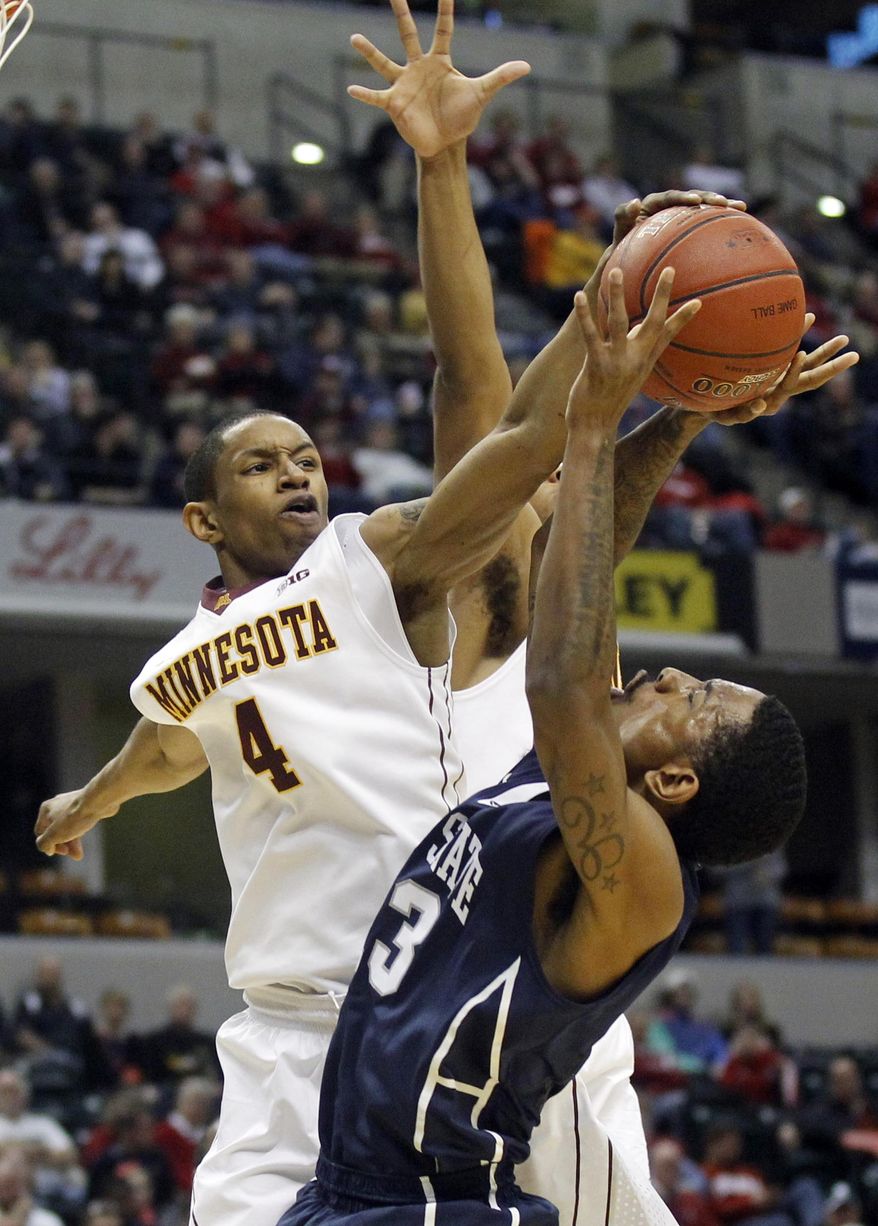 Minnesota guard Deandre Mathieu (4) blocks a shot by Penn State guard Geno Thorpe (13) in the first half of an NCAA college basketball game in the first round of the Big Ten Conference tournament, Thursday, March 13, 2014, in Indianapolis. (AP Photo/Kiichiro Sato)