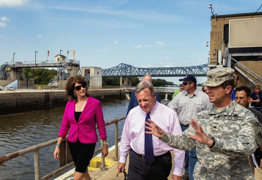 In this Sept. 5, 2013 photo, Col. Mark Deschenes with the U.S. Army Corps of Engineers tells Sen. Dick Durbin, D-Ill., and U.S. Rep. Cheri Bustos about the economic impact of lock and dam operations along the river as they tour the 75-year-old lock and dam in Peoria, Ill. Illinois lawmakers say congressional negotiators are moving toward an agreement on legislation authorizing improvements to shipping channels, flood protections and other waterways projects around the country. Among the Illinois projects are the lock and dam in Peoria and the Olmsted Lock and Dam between Illinois and Kentucky. (AP Photo/Journal Star, Fred Zwicky)