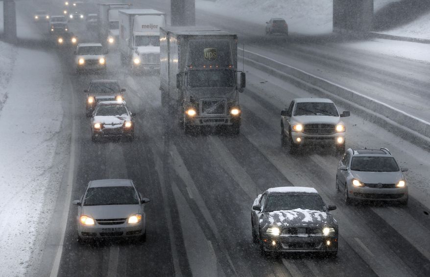 Traffic moves on Interstate 94 during a snow storm in Detroit, Wednesday, March 12, 2014. The storm will likely move the Detroit area close to the seasonal snow total of 93.6 inches set in 1880-1881, according to the National Weather Service. (AP Photo/Paul Sancya)
