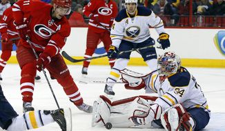 Carolina Hurricanes&#39; Jordan Staal (11) charges into Buffalo Sabres goalie Michal Neuvirth (34), of the Czech Republic, during the second period of an NHL hockey game in Raleigh, N.C., Thursday, March 13, 2014. (AP Photo/Karl B DeBlaker)