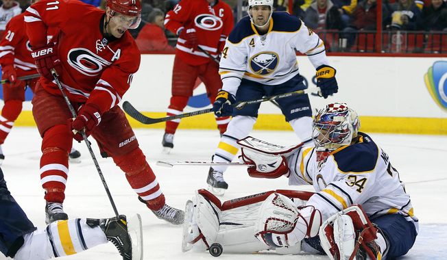 Carolina Hurricanes&#x27; Jordan Staal (11) charges into Buffalo Sabres goalie Michal Neuvirth (34), of the Czech Republic, during the second period of an NHL hockey game in Raleigh, N.C., Thursday, March 13, 2014. (AP Photo/Karl B DeBlaker)