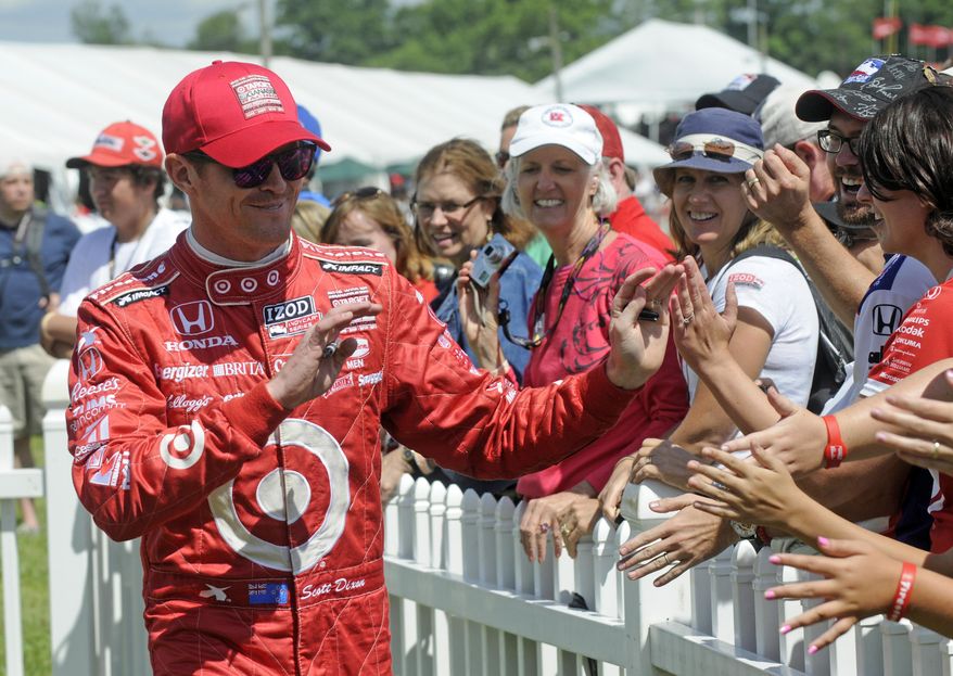 FILE - In this Aug. 4, 2013 file photo, Scott Dixon, of New Zealand, greets fans during driver introductions at the Honda Indy 200 at Mid-Ohio in Lexington, Ohio. Sponsors come and go in motor sports, where even the strongest partnerships can quickly unravel because of the economy, a difference of opinion or a change in marketing strategy. But Chip Ganassi has developed a partnership with Target that has lasted 25 years in counting, and the team owner considers the relationship with the retail giant a key element in the growth of his race team and Ganassi himself. (AP Photo/Tom E. Puskar, File)