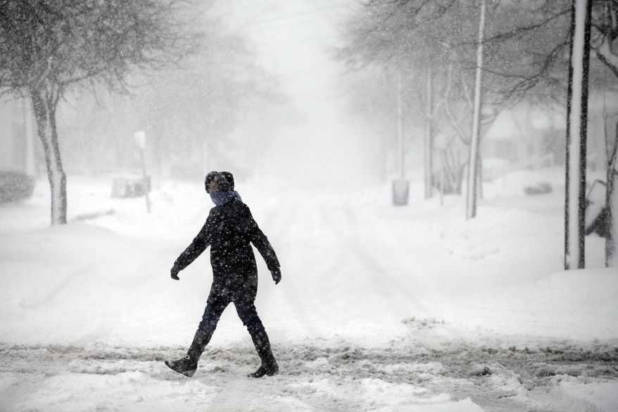 A woman crosses the street through the snow, Wednesday, March 12, 2014, in Bowling Green, Ohio. A winter storm warning was in effect Wednesday for much of northern Ohio, where 4 to 8 inches of snow are expected. (AP Photo/Sentinel-Tribune, J.D. Pooley) MANDATORY CREDIT, TOLEDO BLADE OUT