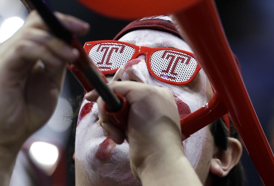 A member of the Temple band plays in the first half of an NCAA college basketball game between Temple and Central Florida at the American Athletic Conference men's tournament Wednesday, March 12, 2014, in Memphis, Tenn. (AP Photo/Mark Humphrey)