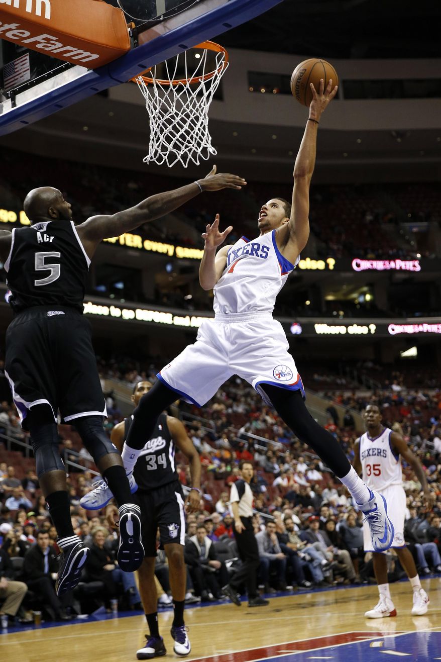 Philadelphia 76ers's Michael Carter-Williams, front right, goes up to shoot against Sacramento Kings's Quincy Acy during the second half of an NBA basketball game on Wednesday, March 12, 2014, in Philadelphia. Sacramento won 115-98. (AP Photo/Matt Slocum)