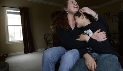 In this March 12, 2014 photo, Heidi Elbarky, 39, hugs her son, Omar, 8, after giving him a dosage of insulin using his insulin pump at home in Spring Hill, Tenn. Tennessee lawmakers are considering a bill that would add insulin to the list of medications school personnel can be trained to administer. (AP Photo/Mark Zaleski)