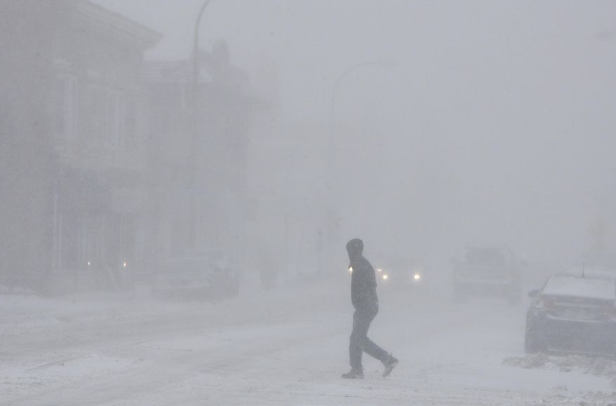 A lone pedestrian crosses Monroe Ave in near white-out conditions, Wednesday, March 12, 2014 in Rochester, N.Y. Many business and government offices closed early ahead of a winter storm. (AP Photo/Democrat & Chronicle, Shawn Dowd) MAGS OUT NO SALES