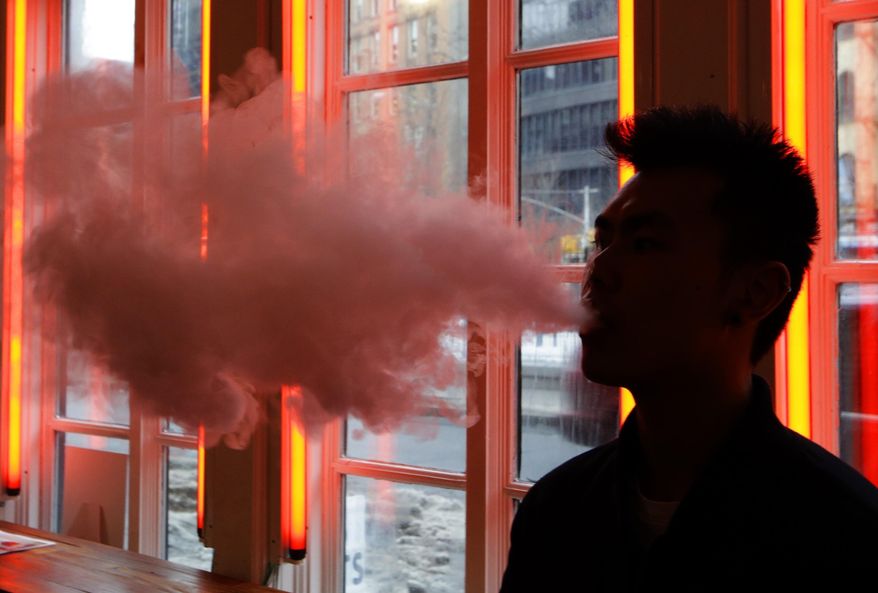 ** FILE ** In this Feb. 20, 2014, photo, a patron exhales vapor from an e-cigarette at the Henley Vaporium in New York. The proprietors are peddling e-cigarettes to "vapers" in a growing movement that now includes celebrity fans and YouTube gurus, online forums and vapefests around the world. (AP Photo/Frank Franklin II)