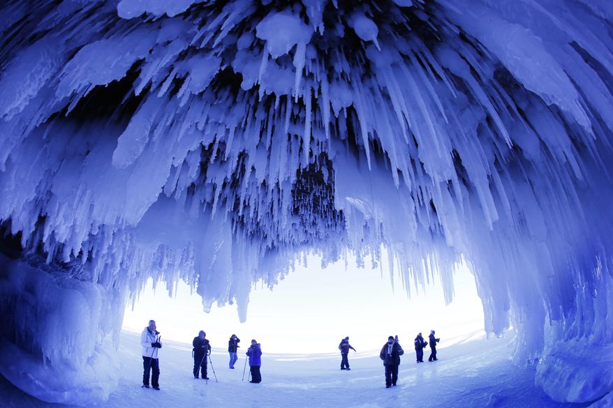 FILE - In this Feb. 2, 2014 photo, people visit the caves at Apostle Islands National Lakeshore in northern Wisconsin, transformed into a dazzling display of ice sculptures by the arctic siege that gripped the Upper Midwest. The popular ice caves on Lake Superior will soon be closed due to ice melt, according to the Apostle Islands National Lakeshore Superintendent. The caves are usually accessible only by water, but Lake Superior’s rock-solid ice cover is letting people walk to them for the first time since 2009. (AP Photo/Minneapolis Star Tribune, Brian Peterson)