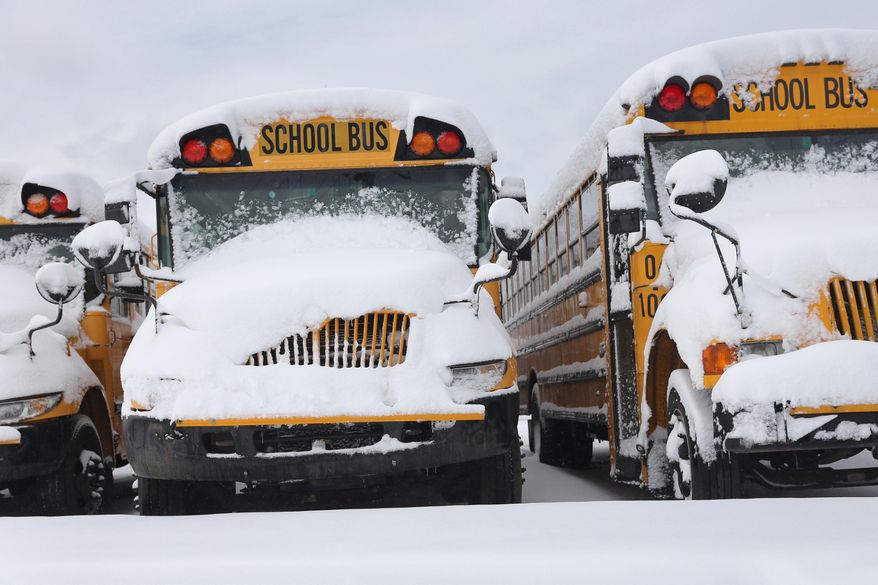 Snow covers school buses parked in a lot after a snow storm Wednesday, March 12, 2014, in Kalamazoo, Mich. (AP Photo/Kalamazoo Gazette-MLive Media Group, Mark Bugnaski) ALL LOCAL TV OUT; LOCAL TV INTERNET OUT