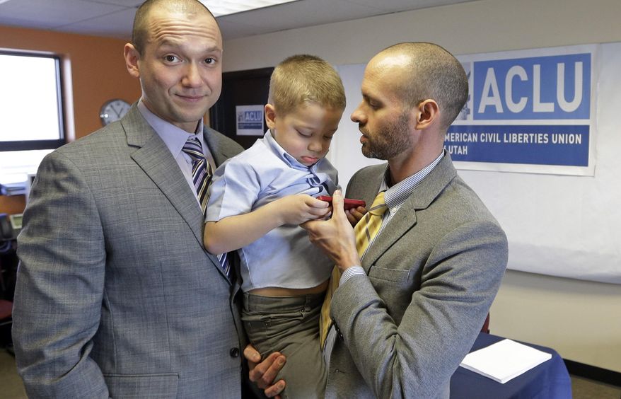 FILE - In this Jan. 21, 2014, file photo, plaintiffs Matthew Barraza, left, looks on as his husband Tony Milner, right, holds their son Jesse, 4, following a news conference in Salt Lake City. A federal judge is set to hear arguments Wednesday morning, March 12, 2014, from four same-sex couples suing Utah over its decision to stop granting benefits to newly married gay couples. The American Civil Liberties Union filed the lawsuit in January saying the state's decision violates the couple's vested rights. (AP Photo/Rick Bowmer, File)