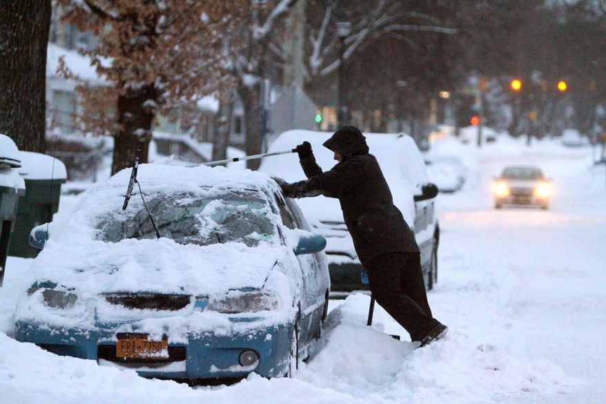 Pete Kostraba cleans off his car in Rochester, N.Y., Wednesday, March 13, 2014. The National Weather Service says high winds and temperatures in the teens and single digits will drive the wind chill well below zero Thursday. (AP Photo/Democrat & Chronicle, Tina Macintyre-Yee) MAGS OUT; NO SALES