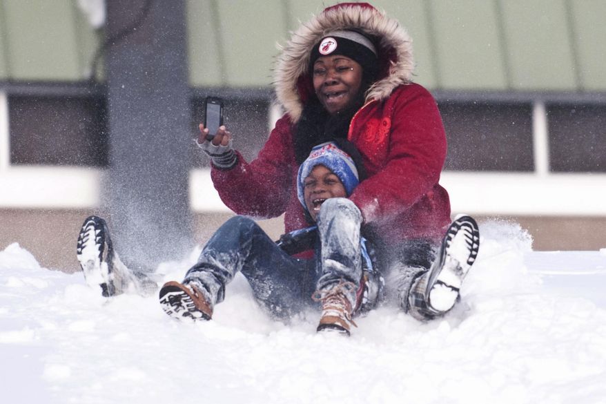 Sharrissa McKinzie, of Flint, sleds down a hill with her son Detrayvion McKinzie, 6, on Wednesday, March 12, 2014, at Flint Southwestern High School in Flint, Mich. (AP Photo/MLive.com The Flint Journal, Katie McLean) LOCAL TV OUT; LOCAL INTERNET OUT.