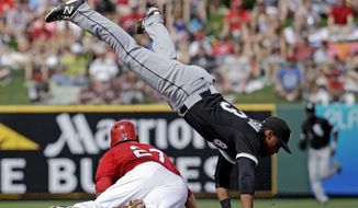 Los Angeles Angels&#39; Mike Trout slides safely under Chicago White Sox&#39;s Micah Johnson as he steals second during the second inning of an exhibition spring training baseball game Thursday, March 13, 2014, in Tempe, Ariz. (AP Photo/Morry Gash)