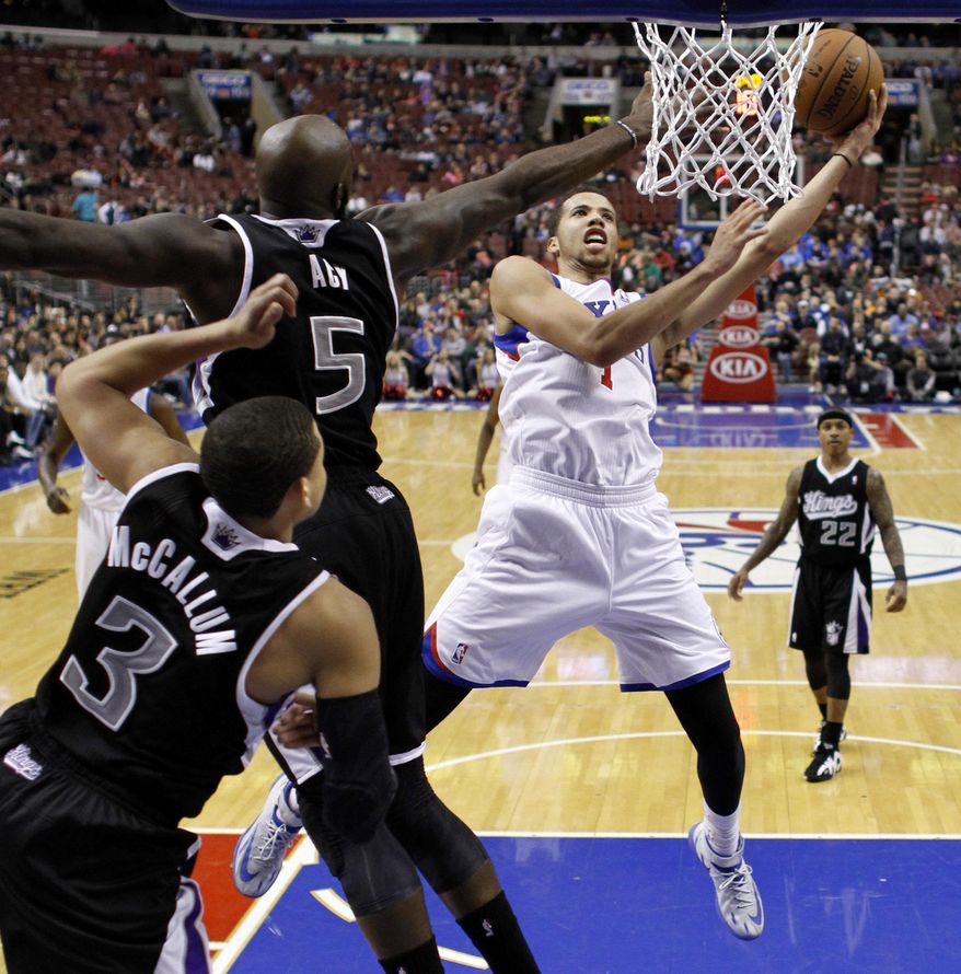 Philadelphia 76ers's Michael Carter-Williams (1) goes up to shoot against Sacramento Kings's Quincy Acy (5) and Ray McCallum (3) during the second half of an NBA basketball game on Wednesday, March 12, 2014, in Philadelphia. Sacramento won 115-98. (AP Photo/Matt Slocum)