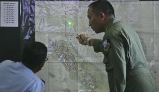 Indonesian Air Force officers examine a map of the Malacca Strait during a briefing following a search operation for the missing Malaysia Airlines Boeing 777, at Suwondo air base in Medan, North Sumatra, Indonesia, Wednesday, March 12, 2014. Malaysia asked India to join the expanding search for the missing jetliner near the Andaman Sea,  far to the northwest of its last reported position and a further sign Wednesday that authorities have no idea where the plane might be more than four days after it vanished. (AP Photo/Binsar Bakkara)