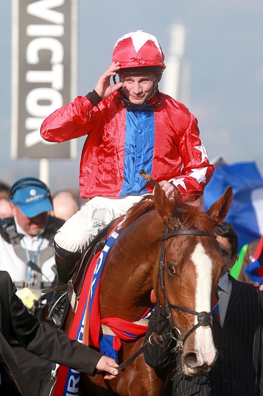 Jockey Jamie Moore on Sire de Grugy acknowledges the cheers after their victory in the Queen Mother Champion chase during day two of the Cheltenham Festival at Cheltenham Racecourse, Cheltenham England Wednesday March 12, 2014. (AP Photo/David Davies/PA) UNITED KINGDOM OUT