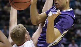 Washington&#39;s Nigel Williams-Goss, right, passes off the ball against Utah&#39;s Jeremy Olsen in the first half of an NCAA Pac 12 conference tournament college basketball game, Wednesday, March 12, 2014, in Las Vegas. (AP Photo/Julie Jacobson)