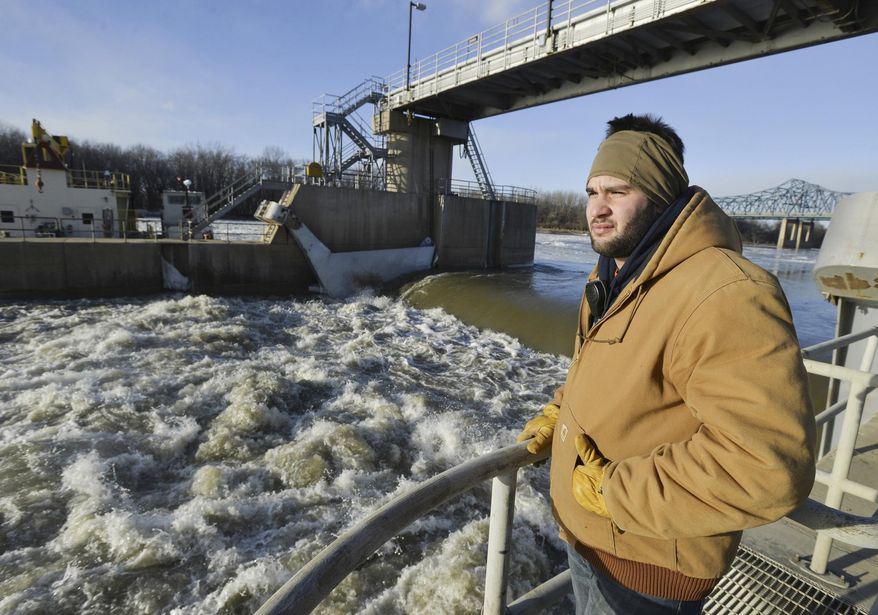 In this Jan. 27, 2014 photo, Dominic Castanza, an operator at the 75-year-old lock and dam in Peoria, Ill., watches the flow of the Illinois River through the locks. Illinois lawmakers say congressional negotiators are moving toward an agreement on legislation authorizing improvements to shipping channels, flood protections and other waterways projects around the country. Among the Illinois projects are the lock and dam in Peoria and the Olmsted Lock and Dam between Illinois and Kentucky. (AP Photo/Journal Star, Ron Johnson)