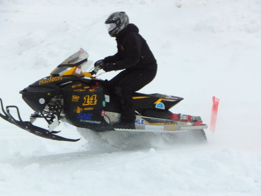 In a March 8, 2014 photo, the Kettering University's snowmobile clears a mogul during the Clean Snowmobile Challenge Internal Combustion category in the Polaris Objective Handling event in Houghton, Mich. Kettering took 1st place in the clean snowmobile challenge at Michigan Tech University. (AP Photo/The Daily Mining Gazette, Dan Roblee)