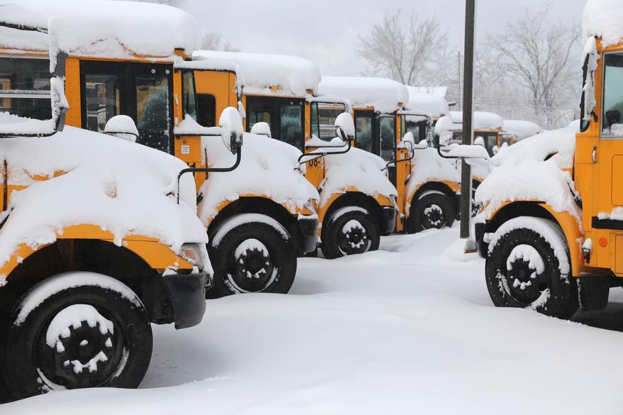Snow covers school buses parked in after a snow storm Wednesday, March 12, 2014, in Kalamazoo, Mich. (AP Photo/Kalamazoo Gazette-MLive Media Group, Mark Bugnaski) ALL LOCAL TV OUT; LOCAL TV INTERNET OUT