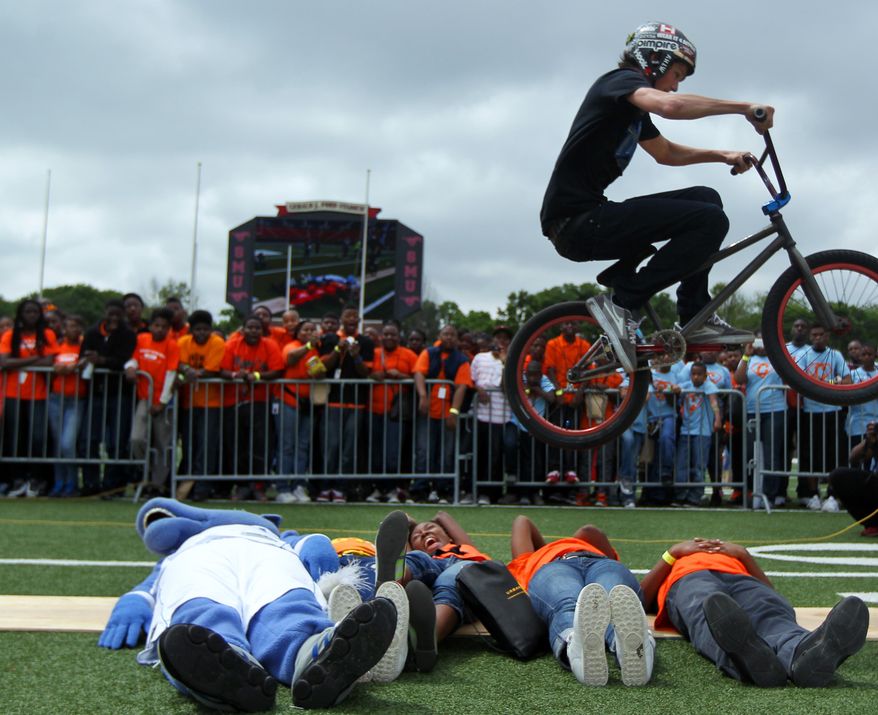 ADVANCE FOR RELEASE MONDAY, MARCH 17, 2014, AND THEREAFTER - In this Saturday, April 27, 2013 photo, BMX trick riders entertain the crowd of kids before guests appear on stage at a celebration event at SMU's Ford Stadium, in Dallas, for the Imagine 2020 initiative, which focuses on inspiring students despite obstacles through engagement, education, and various resources. The multi-million dollar initiative that targets struggling Dallas Independent School District campuses has taken off, and some principals say it's paying off. (AP Photo/The Dallas Morning News, Mona Reeder) MANDATORY CREDIT; MAGS OUT; TV OUT; INTERNET USE BY AP MEMBERS ONLY; NO SALES