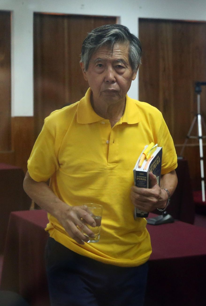 Jailed former President Alberto Fujimori, photographed through a glass window, leaves a courtroom at a police base on the outskirts of Lima, Peru, Thursday, March 13, 2014. Fujimori’s attending neurologist says that the former president suffered a stroke early Friday, March 14, 2014, at the police compound where the 75-year-old is serving a 25-year sentence for authorizing death squads. (AP Photo/Martin Mejia)
