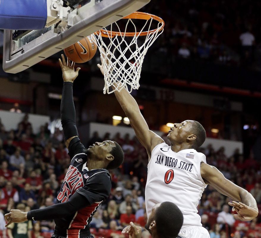 San Diego State's Skylar Spencer blocks a shot from UNLV's Deville Smith during the first half of an NCAA college basketball game in the semifinals of the Mountain West Conference tournament Friday, March 14, 2014, in Las Vegas. (AP Photo/Isaac Brekken)